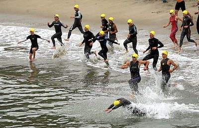 The first wave of triathletes hit the surf at Seacliff State Beach for the start of the 28th annual Sandman Triathlon on Aug. 4, 2013. (Dan Coyro -- Santa Cruz Sentinel file)