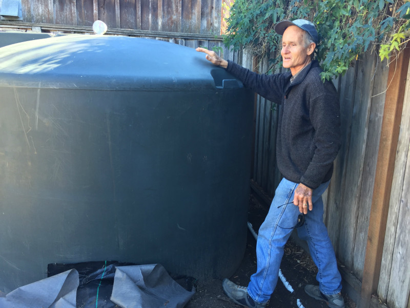 Rainwater catchment expert Golden Love explains how a home cistern works. Pictured at Ron and Molly Sinoway's backyard on the lower Westside.